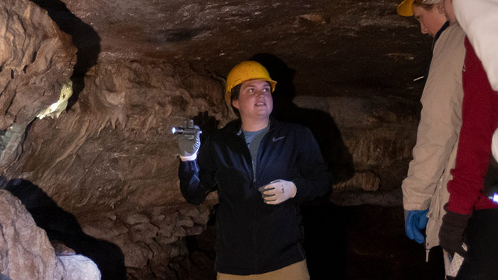 A student explaining karst to other students in a cave