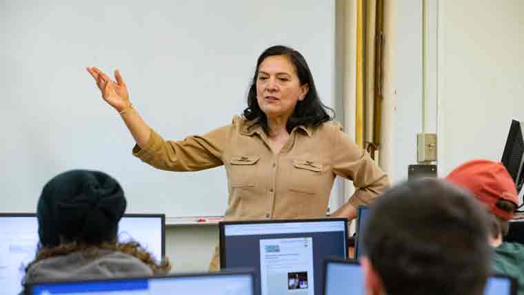 Faculty member leading a class where each student will be working a computer.
