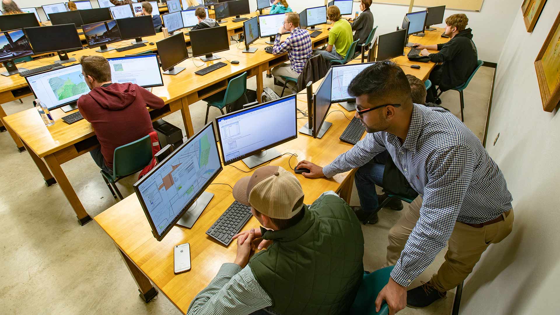Students working on computers in a GIS lab classroom.