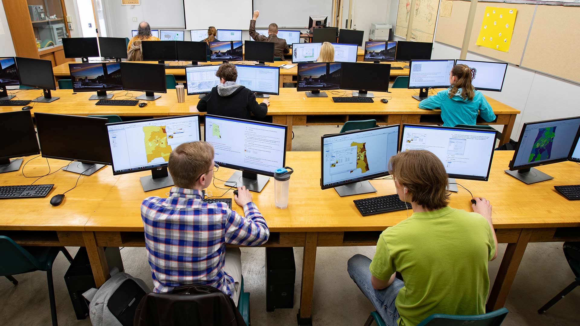 Several students working in a computer lab classroom.