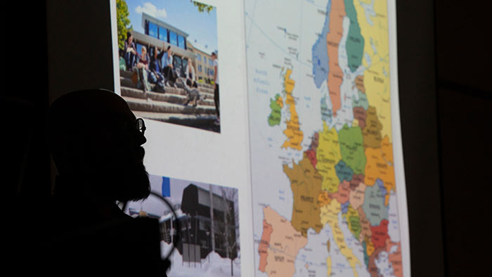 The sillouette of a person looking at a colorful map of Europe.