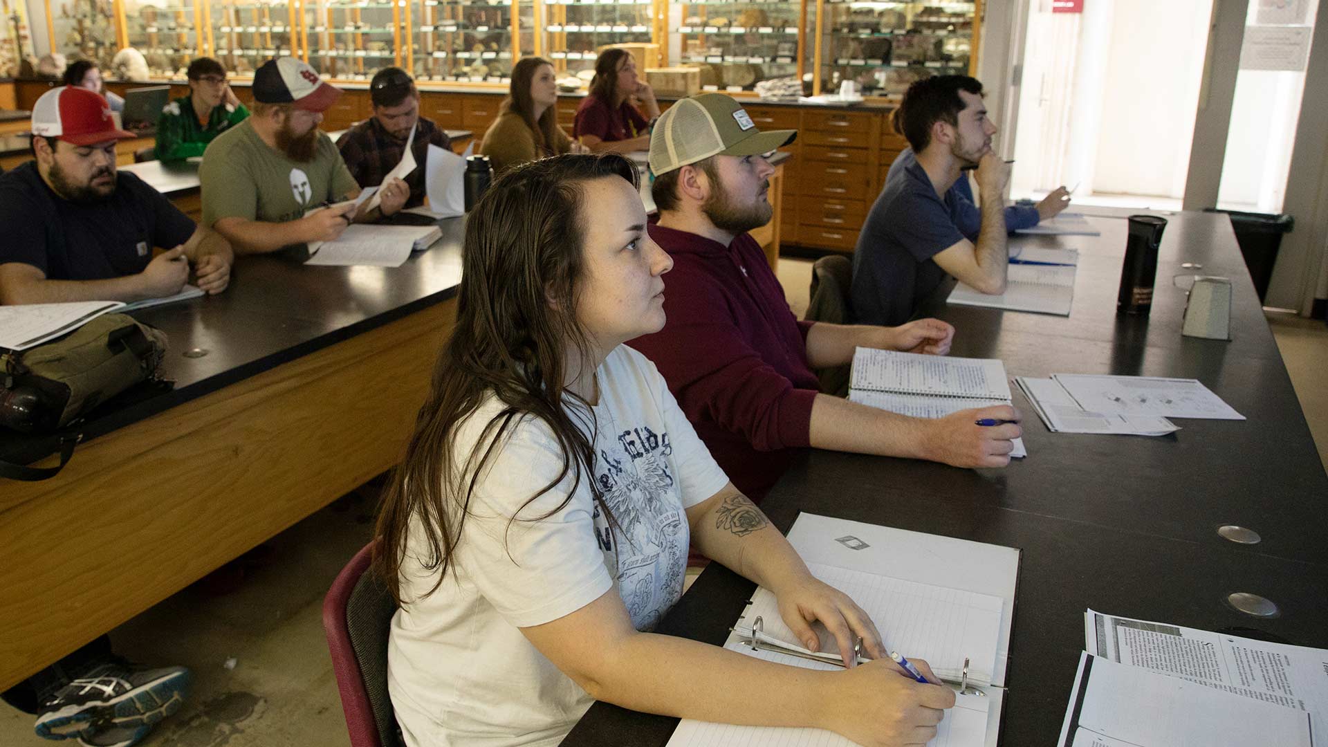 Geology student taking notes in classroom.