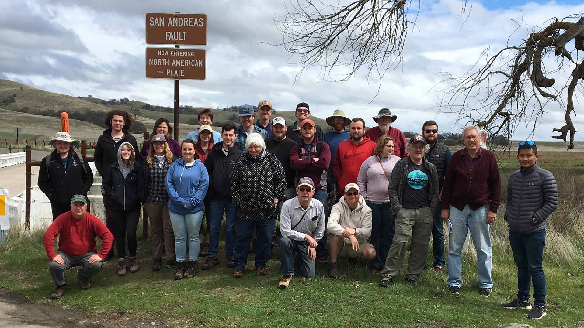 Geology, geography and planning students at San Andreas Fault marker in California.