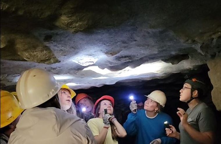 College students learning in a cave