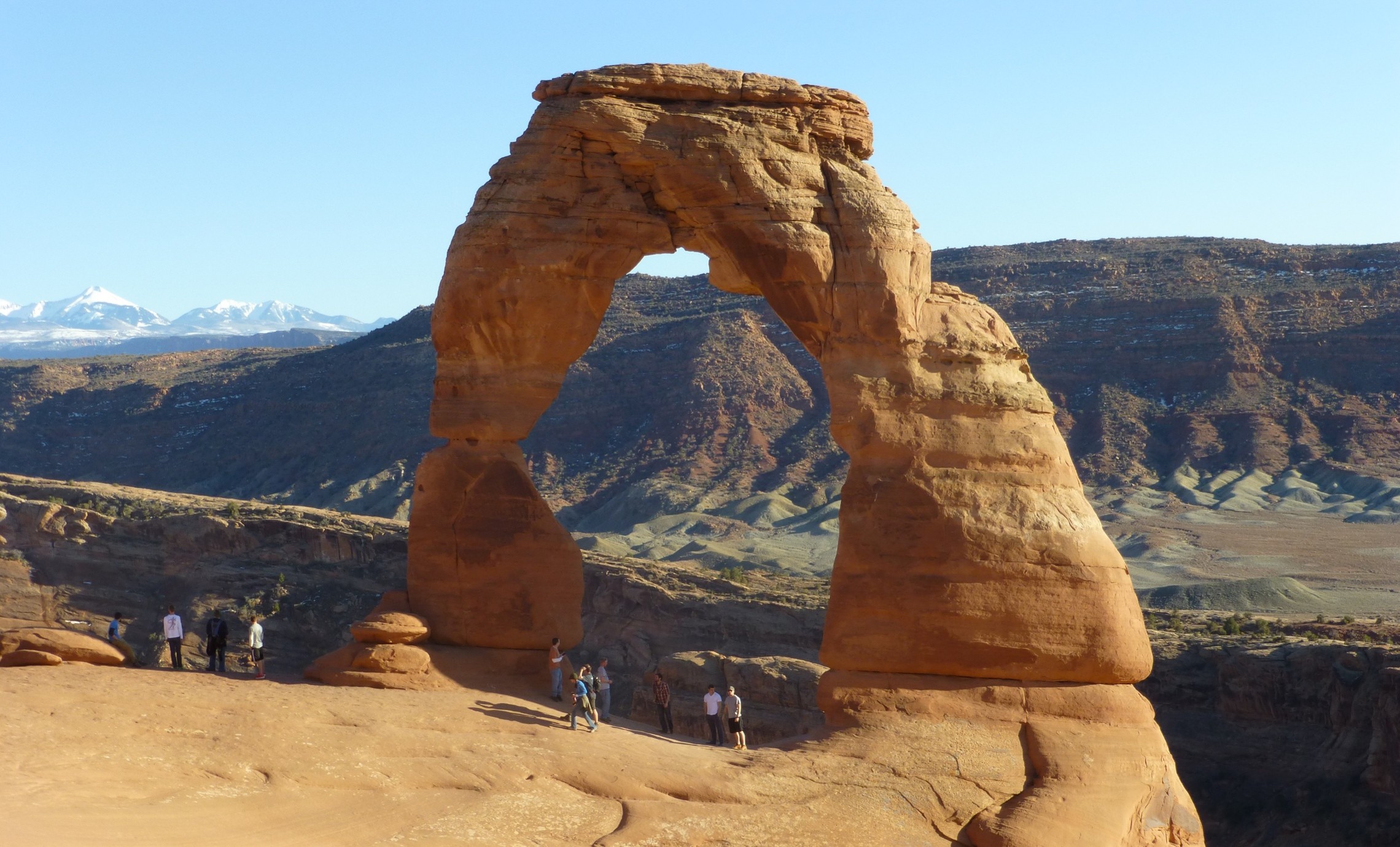 arch at the grand canyon with people standing under it